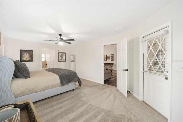 bedroom featuring ceiling fan, light colored carpet, and connected bathroom