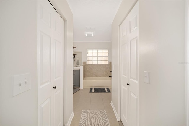 hall featuring light tile patterned flooring