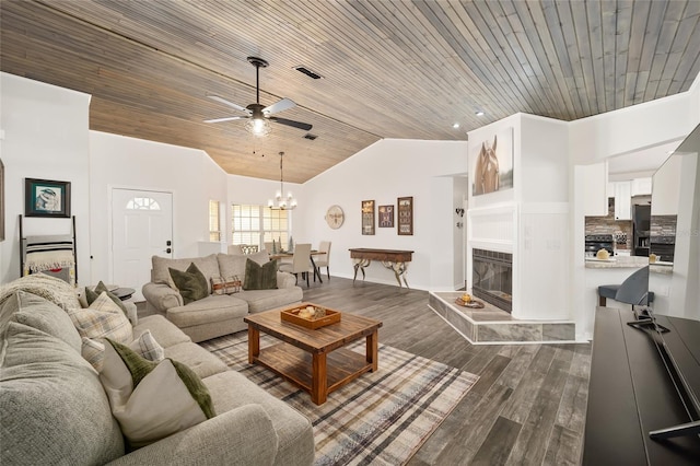 living room featuring dark wood-type flooring, lofted ceiling, ceiling fan with notable chandelier, a tiled fireplace, and wooden ceiling