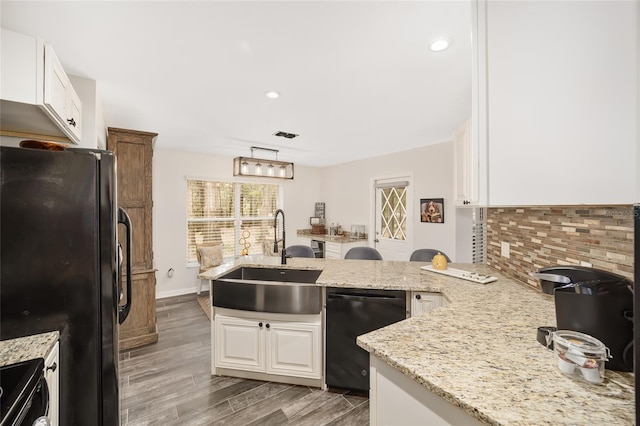 kitchen with black appliances, white cabinetry, kitchen peninsula, and sink