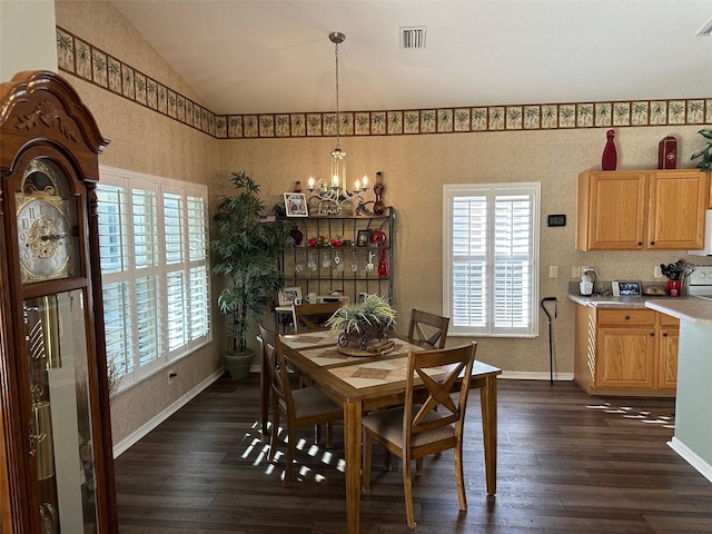 dining space featuring dark wood-type flooring, vaulted ceiling, and a notable chandelier