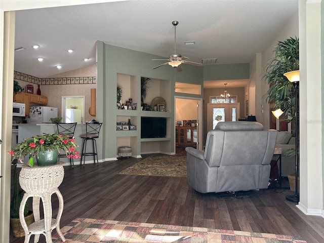 living room featuring built in features, dark wood-type flooring, and ceiling fan with notable chandelier