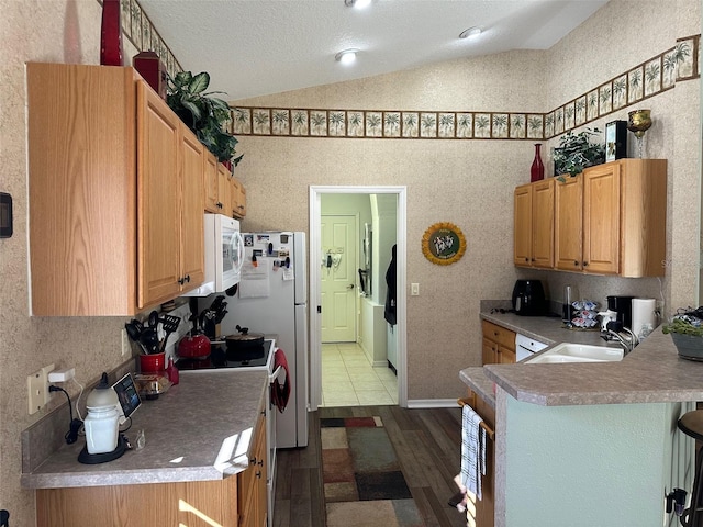 kitchen with kitchen peninsula, light wood-type flooring, white electric range oven, vaulted ceiling, and sink