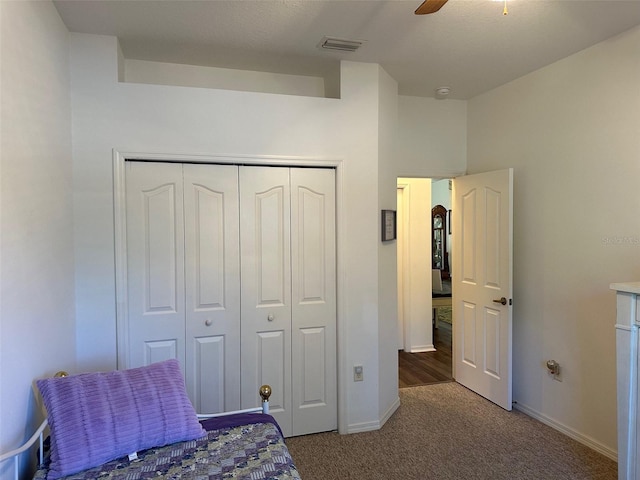 carpeted bedroom with ceiling fan and a closet