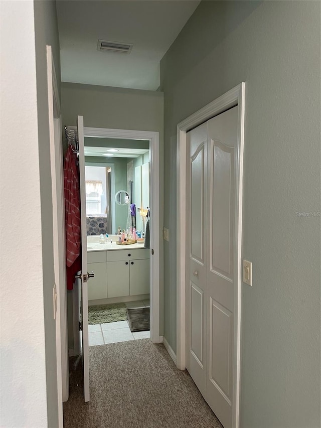 hallway with light colored carpet