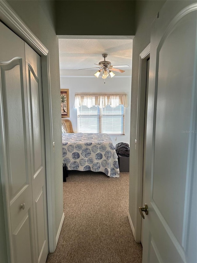 carpeted bedroom featuring a textured ceiling, a closet, and ceiling fan