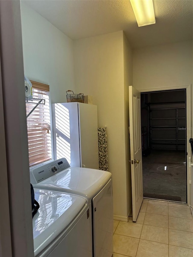 washroom with washer and dryer and light tile patterned floors