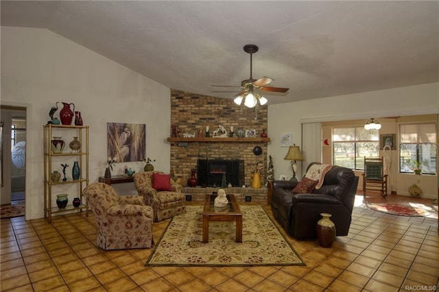 tiled living room featuring a brick fireplace, ceiling fan, and lofted ceiling