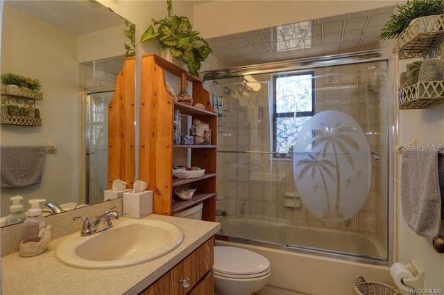 full bathroom with combined bath / shower with glass door, vanity, and toilet