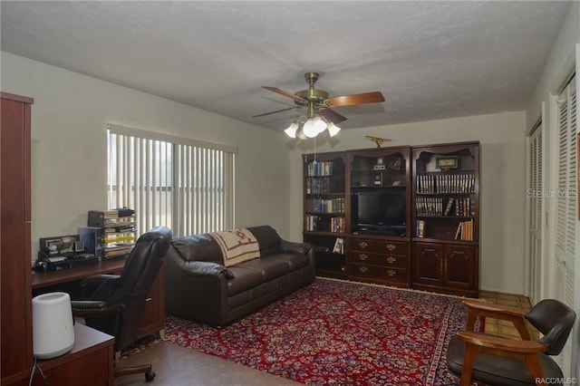 office area with a textured ceiling, carpet floors, and ceiling fan