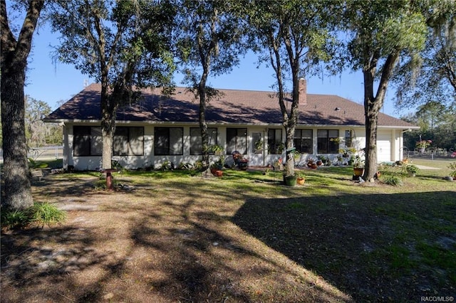 7424 N Nature Trl, Hernando, FL 34442 - rear view of property featuring a garage, a yard, and a chimney