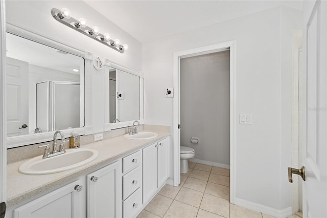 bathroom featuring toilet, vanity, tile patterned floors, and walk in shower