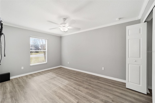 unfurnished room with ceiling fan, a textured ceiling, hardwood / wood-style flooring, and ornamental molding