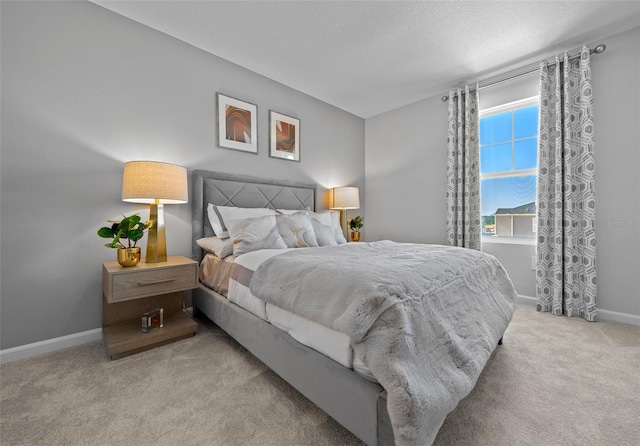 bedroom featuring carpet floors, baseboards, and a textured ceiling