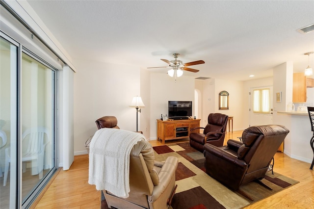 living room featuring light wood-type flooring and ceiling fan