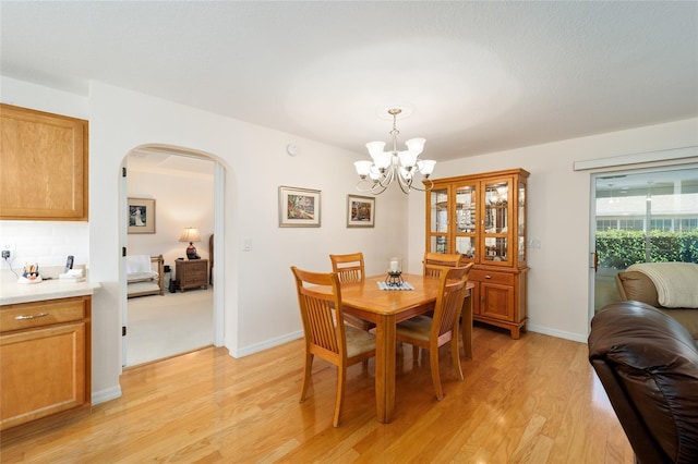 dining area featuring light hardwood / wood-style flooring and a chandelier