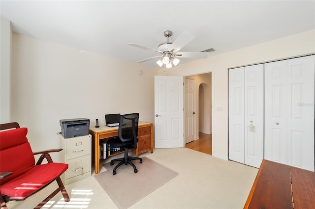 carpeted office space featuring ceiling fan