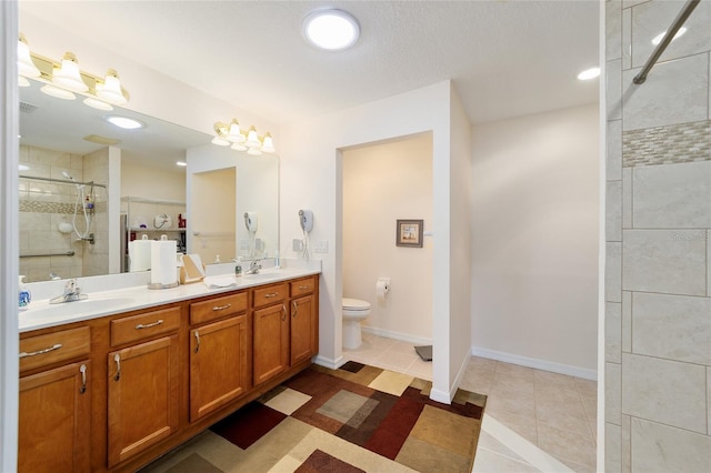 bathroom with tile patterned floors, walk in shower, vanity, and toilet