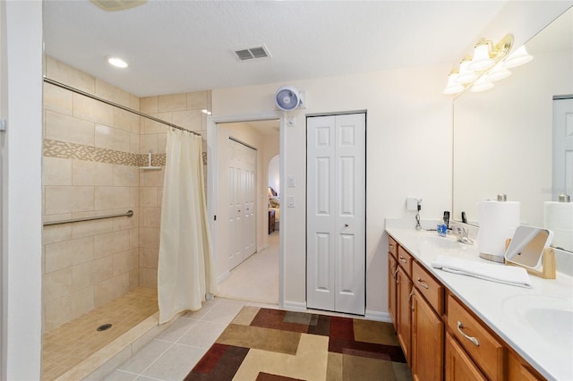 bathroom featuring tile patterned flooring, vanity, and curtained shower