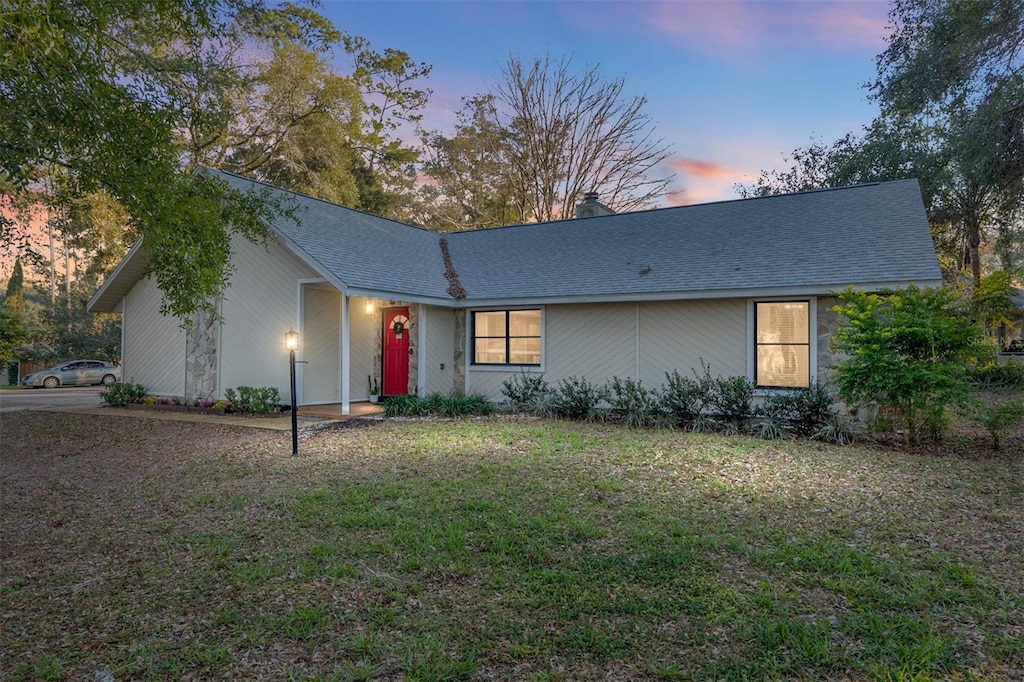 ranch-style home featuring a lawn