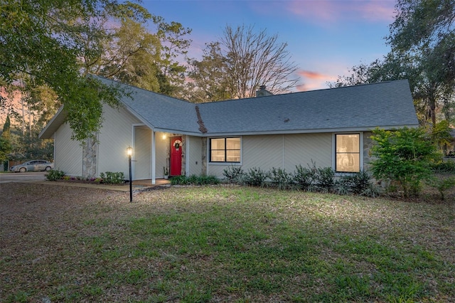 ranch-style home featuring a lawn