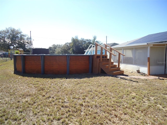 view of yard with a pool and a sunroom