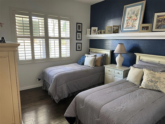 bedroom featuring multiple windows and dark hardwood / wood-style flooring