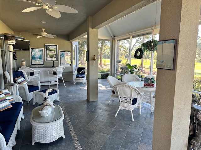 sunroom featuring ceiling fan and vaulted ceiling