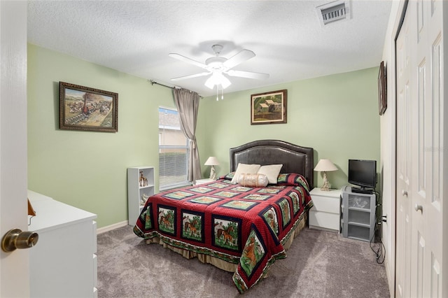 carpeted bedroom featuring a textured ceiling, a closet, and ceiling fan