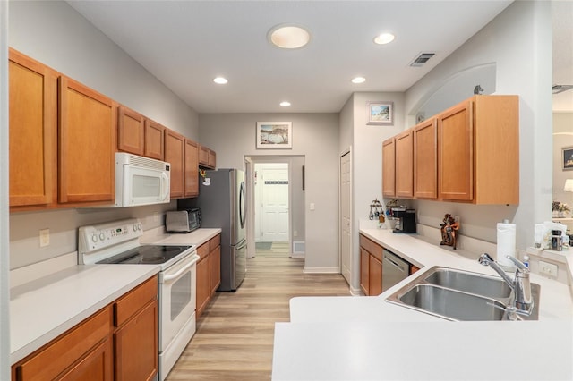 kitchen featuring light wood-type flooring, stainless steel appliances, and sink