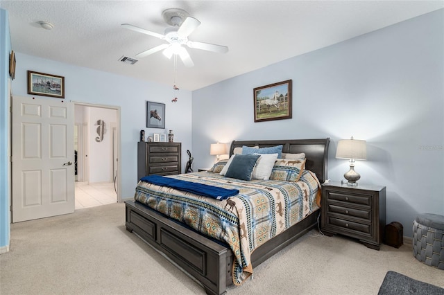 bedroom featuring light carpet, a textured ceiling, and ceiling fan