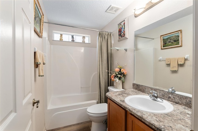 full bathroom with shower / bath combo with shower curtain, vanity, a textured ceiling, and toilet