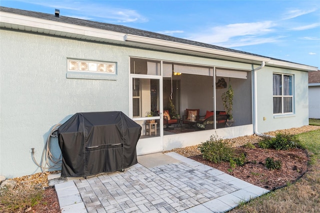 rear view of property with a sunroom and a patio area