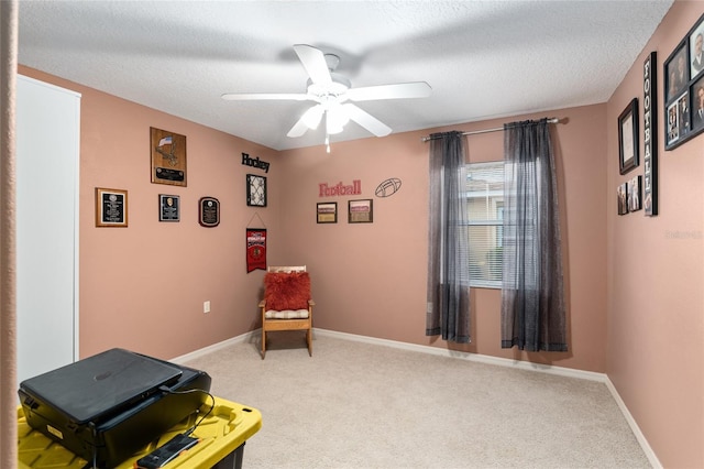 sitting room featuring carpet flooring, a textured ceiling, and ceiling fan