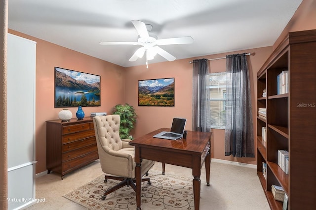 carpeted home office featuring ceiling fan