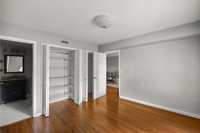 unfurnished bedroom featuring hardwood / wood-style floors and sink