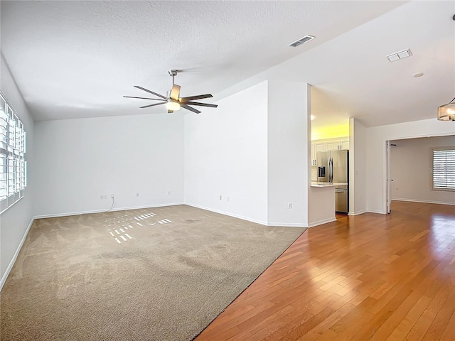 empty room featuring a textured ceiling, hardwood / wood-style flooring, and ceiling fan