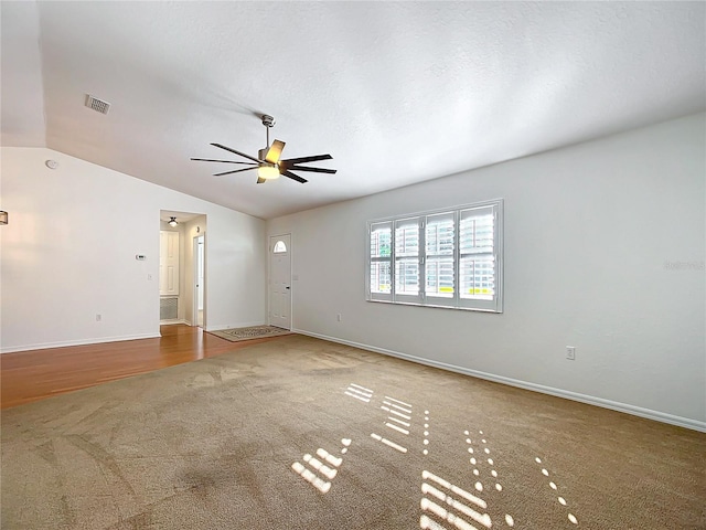 spare room featuring ceiling fan, carpet, and lofted ceiling