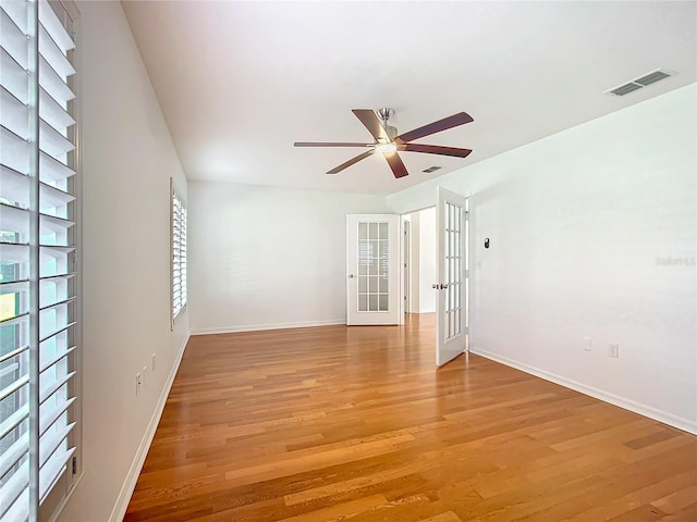 empty room with ceiling fan, french doors, and light hardwood / wood-style flooring