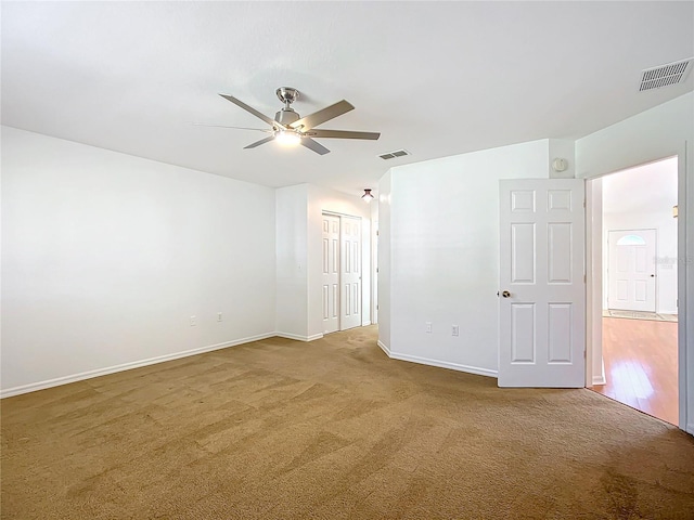 carpeted spare room featuring ceiling fan