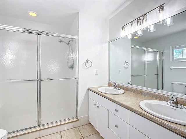 bathroom featuring tile patterned floors, vanity, toilet, and walk in shower