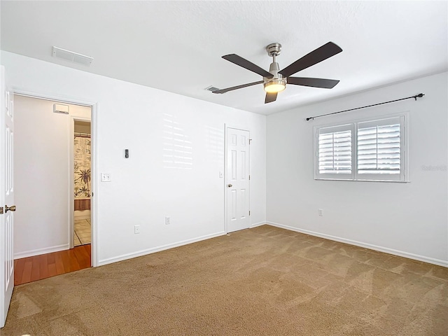 spare room featuring ceiling fan and carpet floors