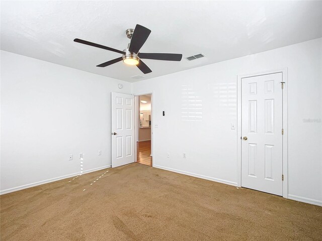 carpeted spare room with ceiling fan