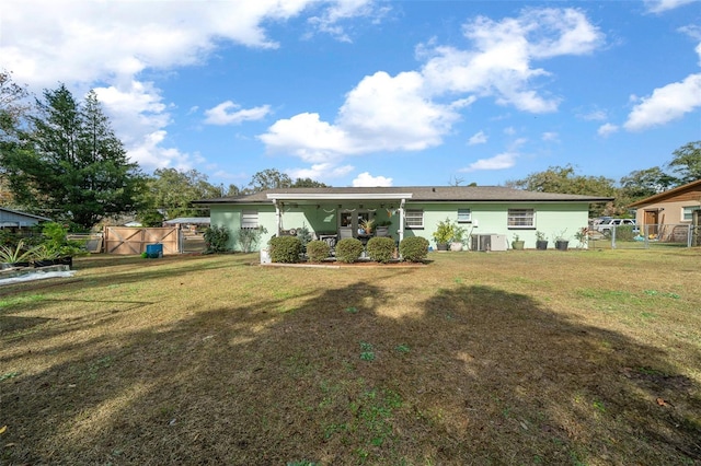 rear view of property with a yard and cooling unit