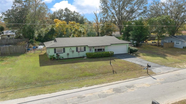 ranch-style house featuring a garage and a front lawn