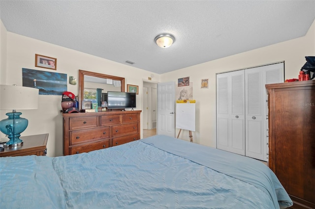 bedroom with a textured ceiling and a closet