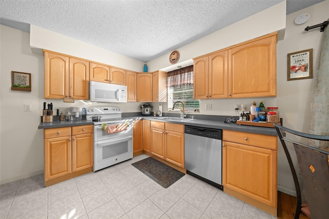 kitchen featuring a textured ceiling, white appliances, and sink