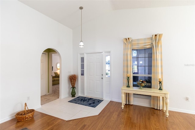 entrance foyer with high vaulted ceiling and light hardwood / wood-style flooring