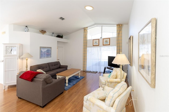 living room with hardwood / wood-style floors and lofted ceiling