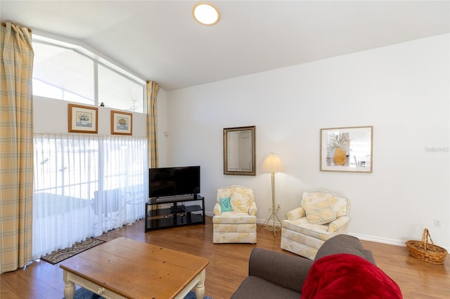 living room with hardwood / wood-style floors, lofted ceiling, and a wealth of natural light